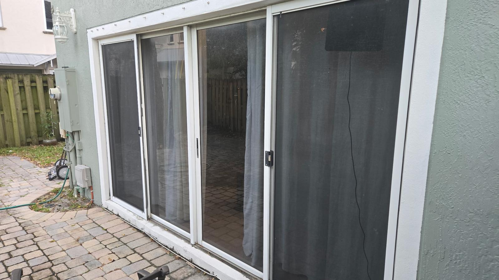 Exterior view of impact sliding glass doors and screen doors on a home