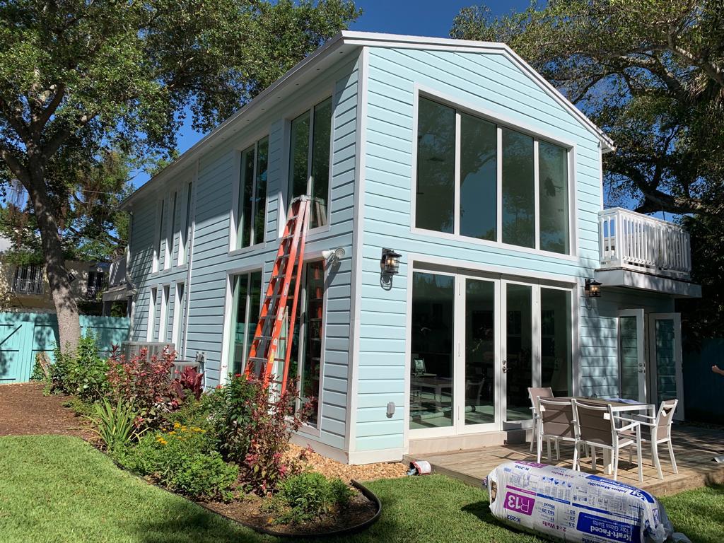 Large impact window and sliding door installation with installers on site
