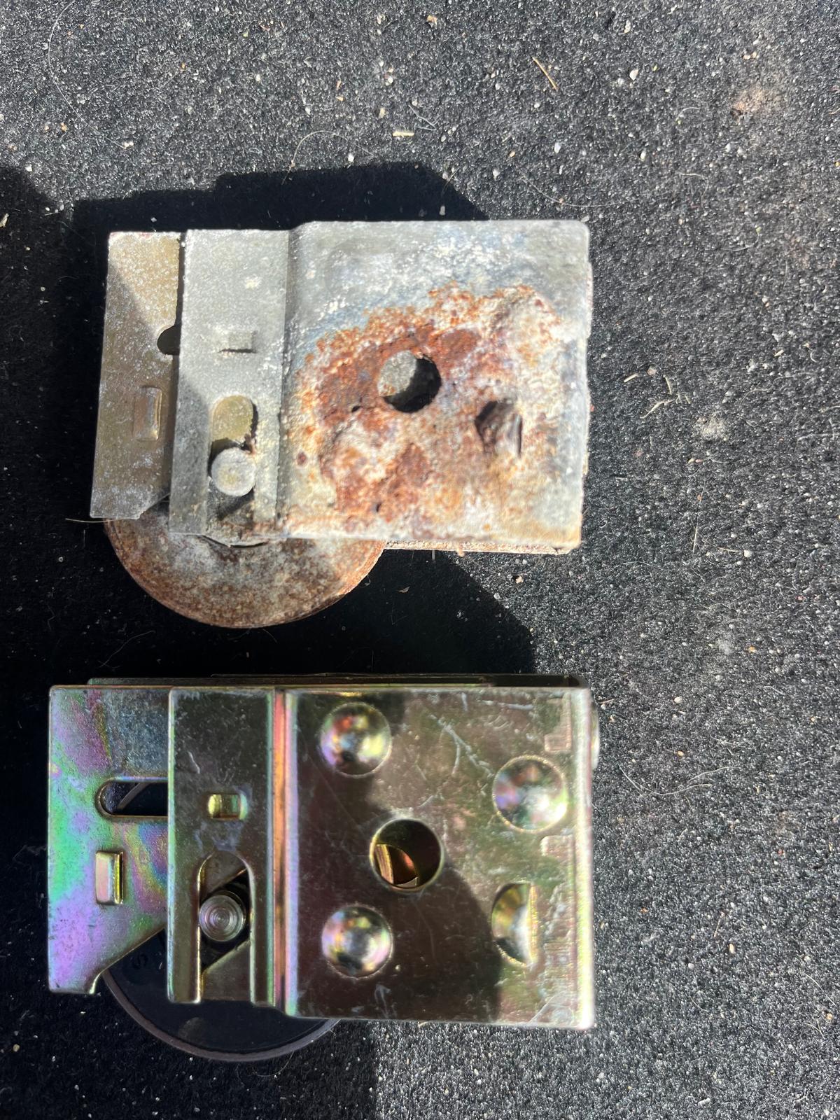 Rusted sliding door roller beside the new hardware we install