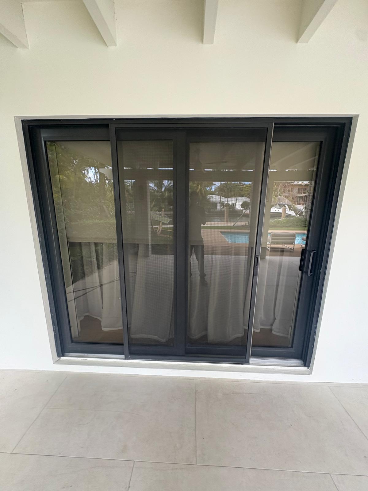 Newly installed dark-frame impact sliding glass door on a South Florida home
